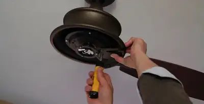 Electrician installing ceiling fan mounting bracket and fixture in Buffalo, NY