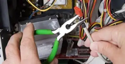 Licensed electrical contractor performing electrical repair with tools in Lancaster, NY