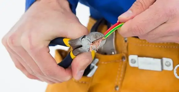 licensed electrician securing electrical wiring with professional tools during service work in Buffalo, NY