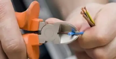 licensed electrician performing precise wire cutting and preparation during electrical service in Buffalo, NY