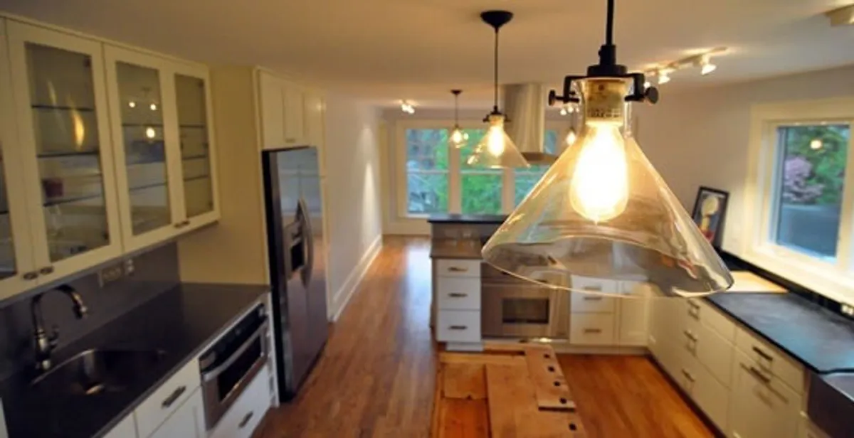 Residential electrician installing modern indoor light fixture in a home in Buffalo, NY