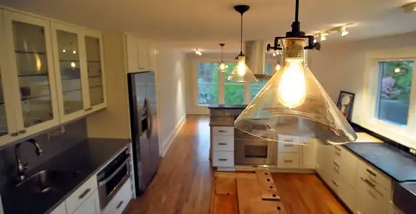 Residential electrician installing modern indoor light fixture in a home in Buffalo, NY